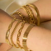 8-piece 18K gold bracelet stack  rope, Cuban, herringbone, paperclip and mesh chains layered on wrist