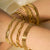 8-piece 18K gold bracelet stackrope, Cuban, herringbone, paperclip and mesh chains layered on wrist