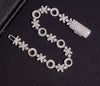 White gold XO moissanite bracelet laid flat showing alternating X and O iced out links with box clasp detail