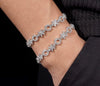 Two XO moissanite tennis bracelets stacked on wrist white gold iced out pave bracelet set
