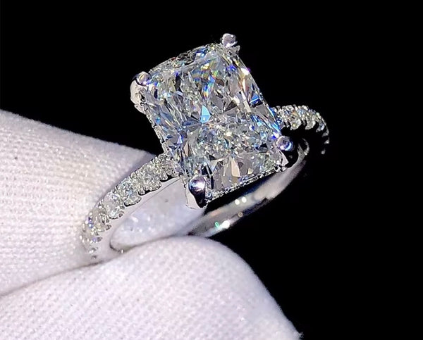 1ct VVS radiant cut moissanite engagement ring in 14K gold PVD-bonded sterling silver pavé setting held in white glove — Twelfth XII