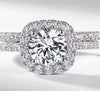 D color VVS1 round moissanite cushion halo split shank engagement ring with matching pavé wedding band in S925 sterling silver on white background — Twelfth XII 2-in-1 bridal set