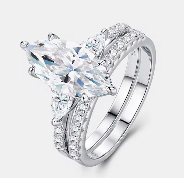 Marquise cut moissanite bridal ring set in sterling silver — angled studio view showing three-stone setting and split shank pavé wedding band