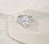 Front view of marquise moissanite engagement ring with pear side stones and round pavé accents — S925 sterling silver bridal set