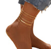 6 piece 14K gold stacked anklet set displayed on ankle — snake, figaro, paperclip, box, rope, and satellite chain styles