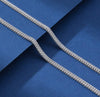 Full-length 4mm double Franco chain necklace in 925 sterling silver draped on royal blue surface
