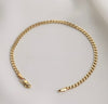 A gold-toned curb chain bracelet with a lobster clasp and tip, displayed on a light gray background.